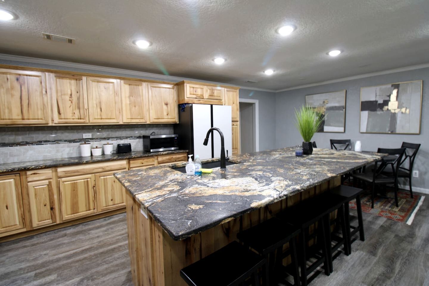 A modern kitchen with wooden cabinets, a granite countertop, and a black faucet.