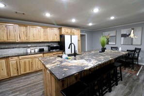 Une cuisine moderne avec des meubles en bois, un plan de travail en granit et un robinet noir.