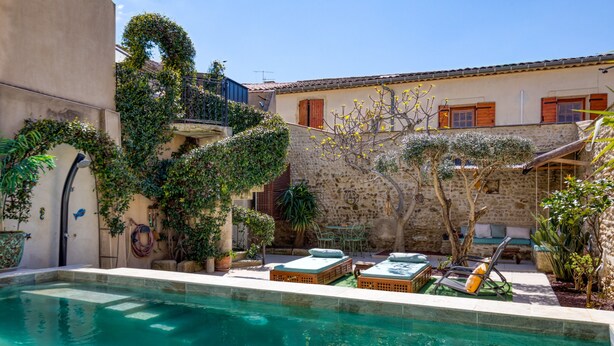 A pool area with a stone wall, a small garden, and outdoor furniture. - Guest Room "La Petite Camargue" with Private Pool, Shared Terrace and Wi-Fi (Vauvert)