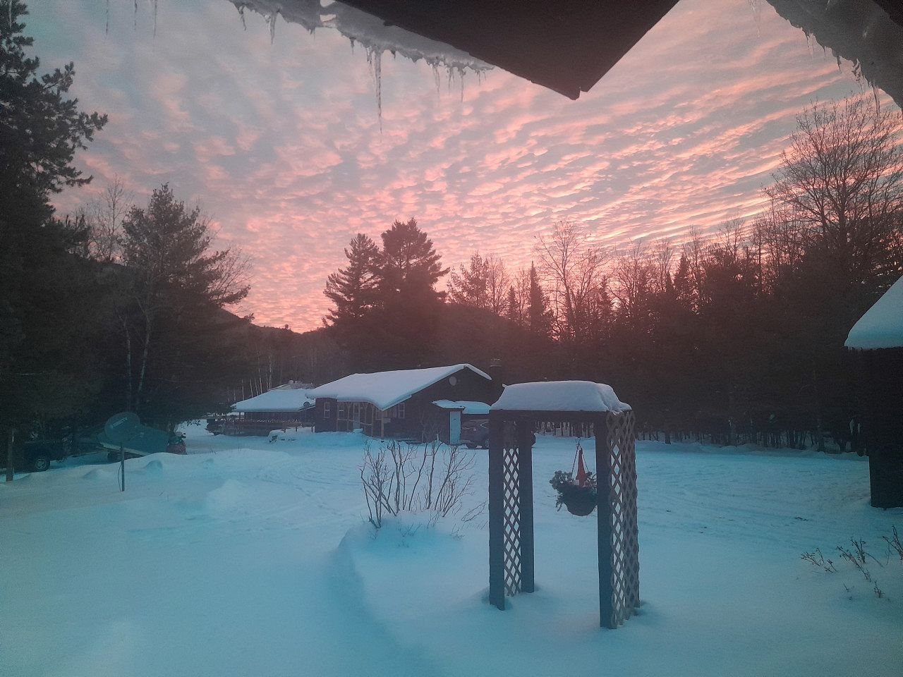 A snowy landscape with a gazebo and a covered area.