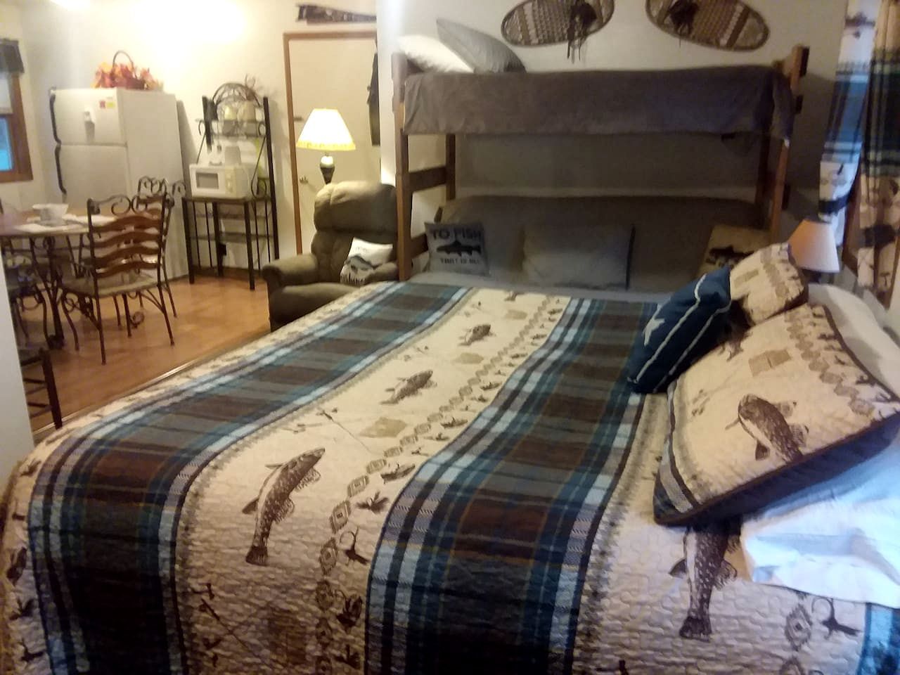 Quarto com beliche, escrivaninha com cadeira, micro-ondas e frigorífico.