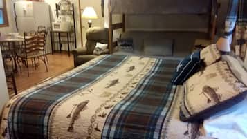 Una habitación con una cama individual, un escritorio con silla, un microondas y un refrigerador.
