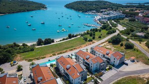 Une zone côtière dotée d’un port de plaisance, de bâtiments modernes et d’une piscine.
