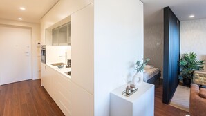 Eine moderne Küche mit weißen Schränken, einem eingebauten Backofen und einem großen Spiegel über der Arbeitsfläche.