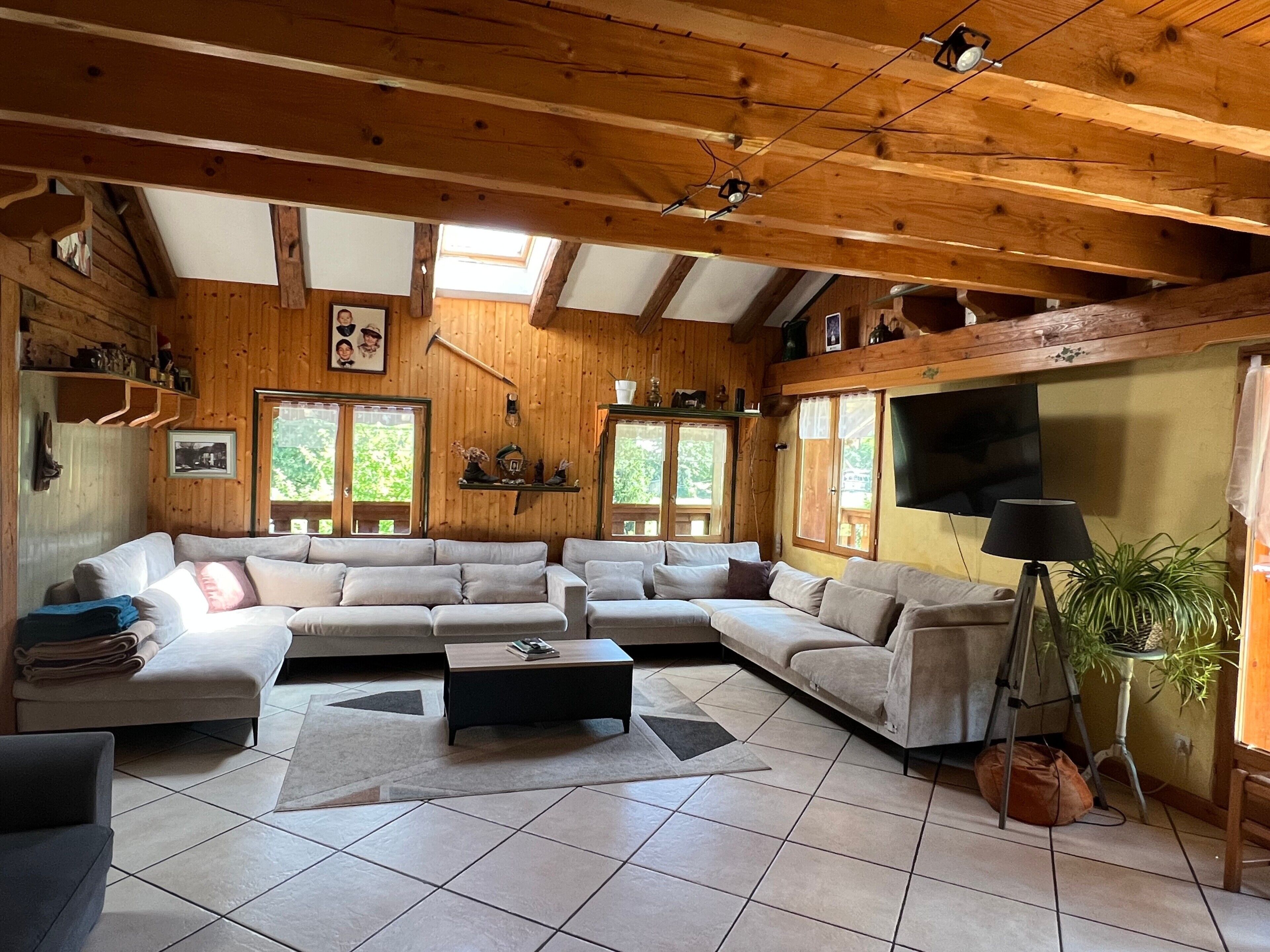 Un salon confortable avec un canapé d’angle, une table basse et un téléviseur.
