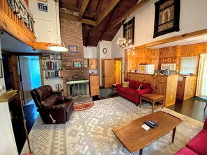 A cozy living room with a fireplace, leather sofa, and a coffee table. - Spacious Retreat for a White Mountains Vacation Getaway (Franconia)