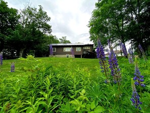 A residential building with a front lawn and surrounding greenery. - Spacious Retreat for a White Mountains Vacation Getaway (Franconia)
