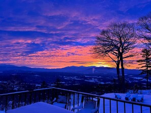 A snowy landscape with a sunset, a tree, and a railing. - Unique White Mountains Vacation Rental for Family Getaways in New England (Dalton)