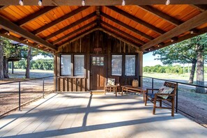 Une cabane en bois avec une véranda, une table et deux chaises.