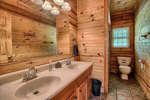 A wooden cabin bathroom with a double sink, a toilet, and a window. - Group Spacious Cabin with Hot-Tub and Picnic Areas in Ohio (Rockbridge)