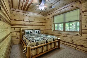 A wooden cabin room with a bed, a window, and a ceiling fan. - Group Spacious Cabin with Hot-Tub and Picnic Areas in Ohio (Rockbridge)