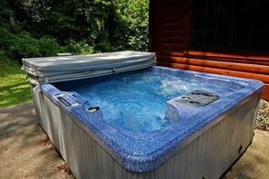 A hot tub with a stone exterior, a control panel, and a wooden deck surrounding it. - Group Spacious Cabin with Hot-Tub and Picnic Areas in Ohio (Rockbridge)