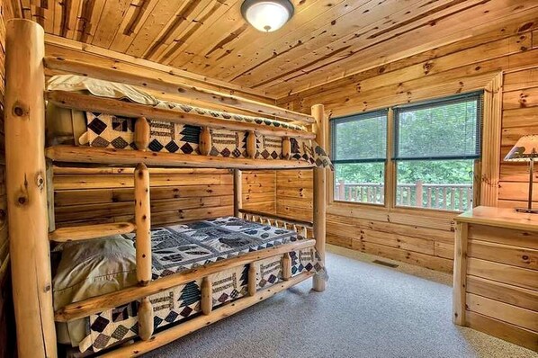 A wooden cabin interior with a bunk bed, a window with a view, and a desk with a lamp. - Group Spacious Cabin with Hot-Tub and Picnic Areas in Ohio (Rockbridge)
