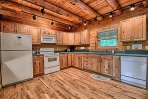 A kitchen with wooden cabinets, a refrigerator, stove, microwave, and dishwasher. - Group Spacious Cabin with Hot-Tub and Picnic Areas in Ohio (Rockbridge)