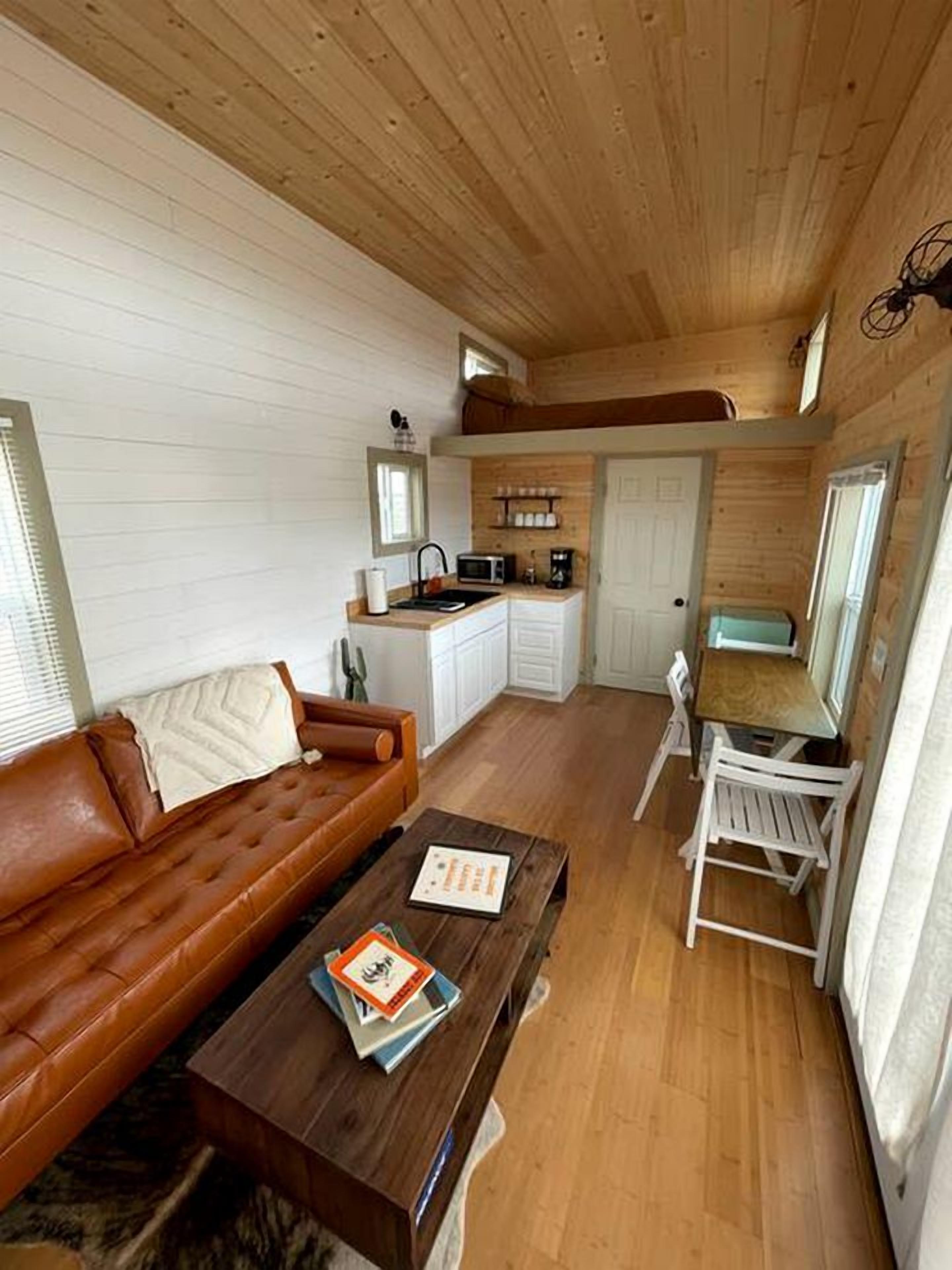A compact living space with a kitchenette, a sofa, a coffee table, and a dining area.
