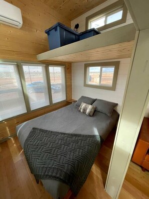 Quarto com beliche, janela, aquecedor e caixa de armazenamento.