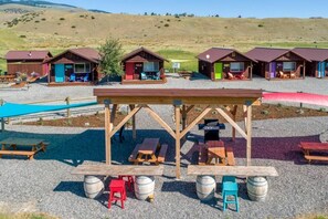 Un terrain de camping doté de cabanes en bois, de tables de pique-nique et de barbecues.