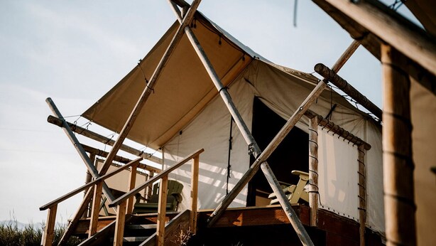 A tent with a simple, functional design, featuring a staircase leading to an entrance, and a basic interior layout.