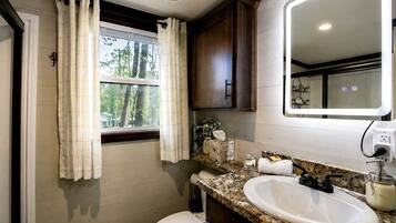 Ein Badezimmer mit Toilette, Waschbecken und einem fenster mit Vorhängen.