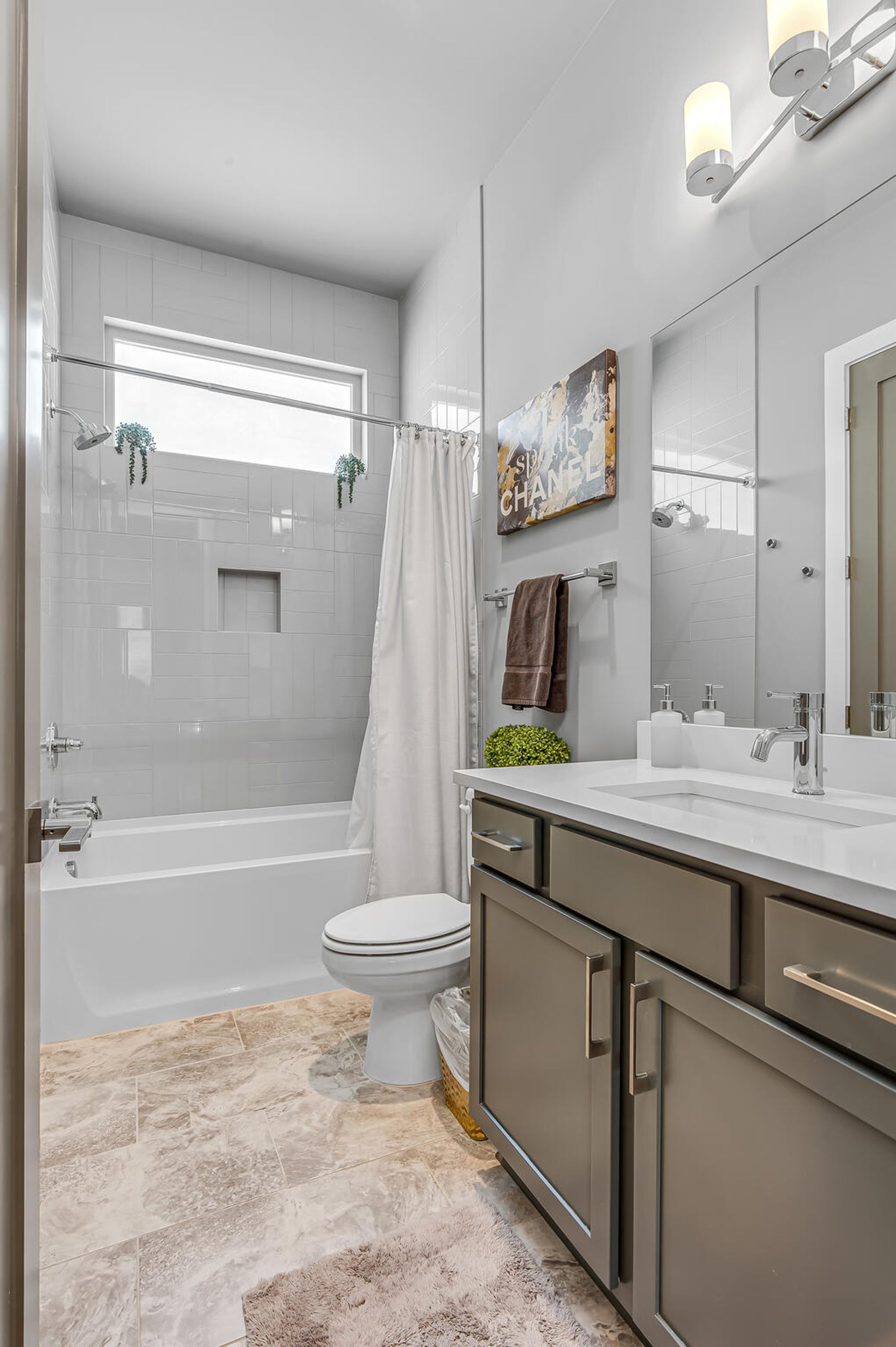 A modern bathroom with a bathtub, toilet, and vanity.