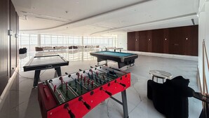 A spacious indoor recreational area with a foosball table, pool table, and ping pong table. - Stayshort - Al Barsha 1BR Sleeps 2 With Private Balcony (Dubai)