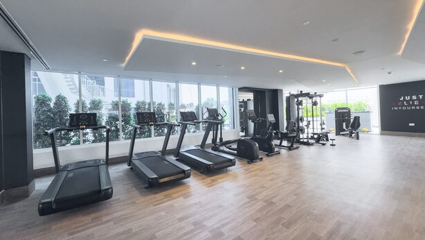 A modern gym with treadmills, elliptical machines, and weight equipment. - Stayshort - Al Barsha 1BR Sleeps 2 With Private Balcony (Dubai)