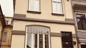 A two-story building with a beige facade, large windows, and a black gate. - Torrinha's Backyard ** Porto Center (Porto)