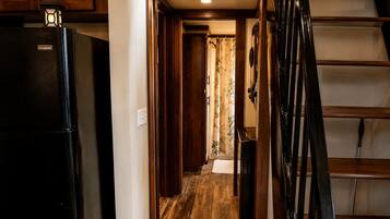 Una cocina con refrigerador, armarios de madera y una escalera.