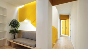 Ein modernes Interieur mit einer eingebauten Bank, einem Blumentopf und einer gelben Akzentwand.