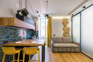 A modern kitchen with a wooden countertop, yellow chairs, and a dining table set for two. - Tribunali Trendy Accommodations by Wonderful Italy (Naples)