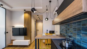 A modern kitchen with a wooden bench, a built-in microwave, and a large island with a stove. - Tribunali Trendy Accommodations by Wonderful Italy (Naples)