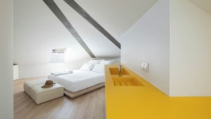 A modern bedroom with a loft-style ceiling, a bed, a bedside table, and a yellow accent wall. - A'Mar - Room D (Póvoa de Varzim)