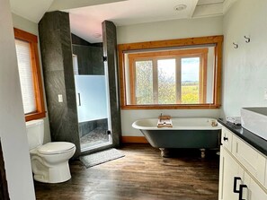 A bathroom with a toilet, a bathtub, and a shower area. - Spacious Farmhouse Estate with Mountain Views & Dual Kitchens near Skiing and Trails in Tetonia, Idaho (Tetonia)