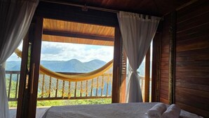 A room with a bed, a hammock, and a view of mountains. - Chácara da Sorte (Pacoti)