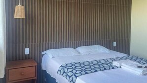A hotel room with a bed, a nightstand, a hanging lamp, and a striped wall. - Chácara da Sorte (Pacoti)