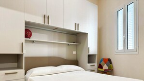 Un dormitorio con cama, armario y ventana.