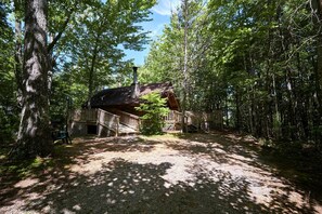 A cabin surrounded by forest with a gravel path leading to it. - Stunning Wooden Cottage with Hot-tub in Sevierville, Tennessee (Sevierville)