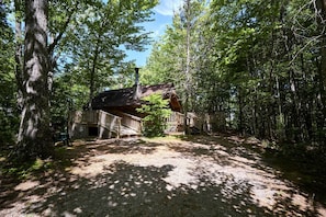 A cabin surrounded by forest with a gravel path leading to it. - Stunning Wooden Cottage with Hot-tub in Sevierville, Tennessee (Sevierville)