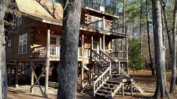 A wooden cabin with a balcony and staircase.