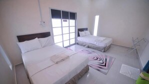Una habitación de hotel con dos camas, un ventanal grande, un taburete verde y un perchero.