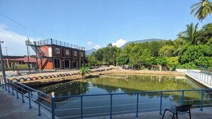 Un edificio con una escalera de incendios, una fuente de agua y vistas a una montaña.