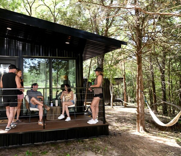 A modern building with a glass facade, surrounded by a forest. - Serene Woodland Cabin Oasis near Trinity River in Texas (Alvord)