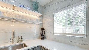 A modern kitchen with a stainless steel sink, a built-in blender, and a window with blinds. - 1 Mi to Las Olas Eats! Modern Apt w/ Shared Patio (Fort Lauderdale)