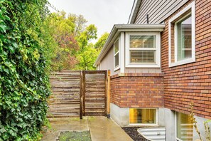 A residential building with a brick exterior, a wooden gate, and a window with blinds. - Ski, Soak & Explore! Central Parkside SLC Apt (Salt Lake City)