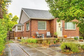 A two-story brick house with a front porch, a small garden, and a mailbox. - Ski, Soak & Explore! Central Parkside SLC Apt (Salt Lake City)