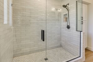A glass-enclosed shower with white tiled walls and floor, a handheld showerhead, and a glass cabinet with a mirror. - Sports Court + Hot Tub: Luxe Scottsdale Retreat! (Scottsdale)