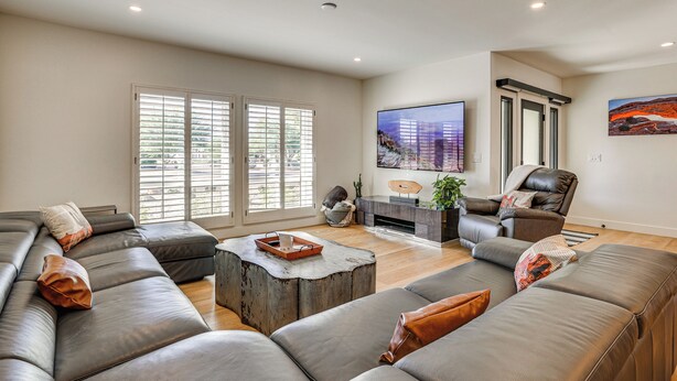 Un salón amplio con un sofá modular grande, una mesa de centro y un televisor de pantalla plana.
