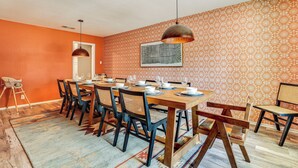 Een eethoek met een lange houten tafel, gedekt voor zes personen, omringd door stoelen met geweven zittingen.
