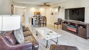 A living room with a fireplace, a television, and a dining area with chairs and a table. - Pool, Lake & Sun! Havasu Hot Spot By London Bridge (Lake Havasu City)