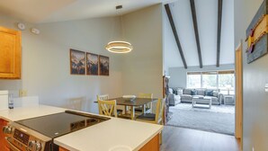 A modern kitchen with a central island, dining area with chairs, and a living room with a sofa and windows. - 4 Mi to Dtwn: Pagosa Springs Gem w/ Mtn Views! (Pagosa Springs)